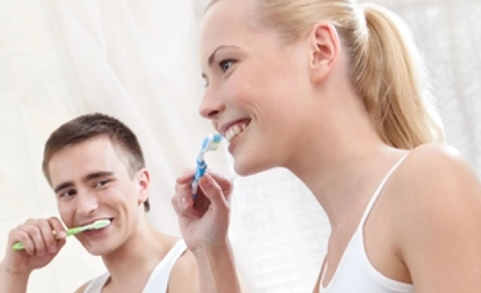 Man and woman brushing their teeth