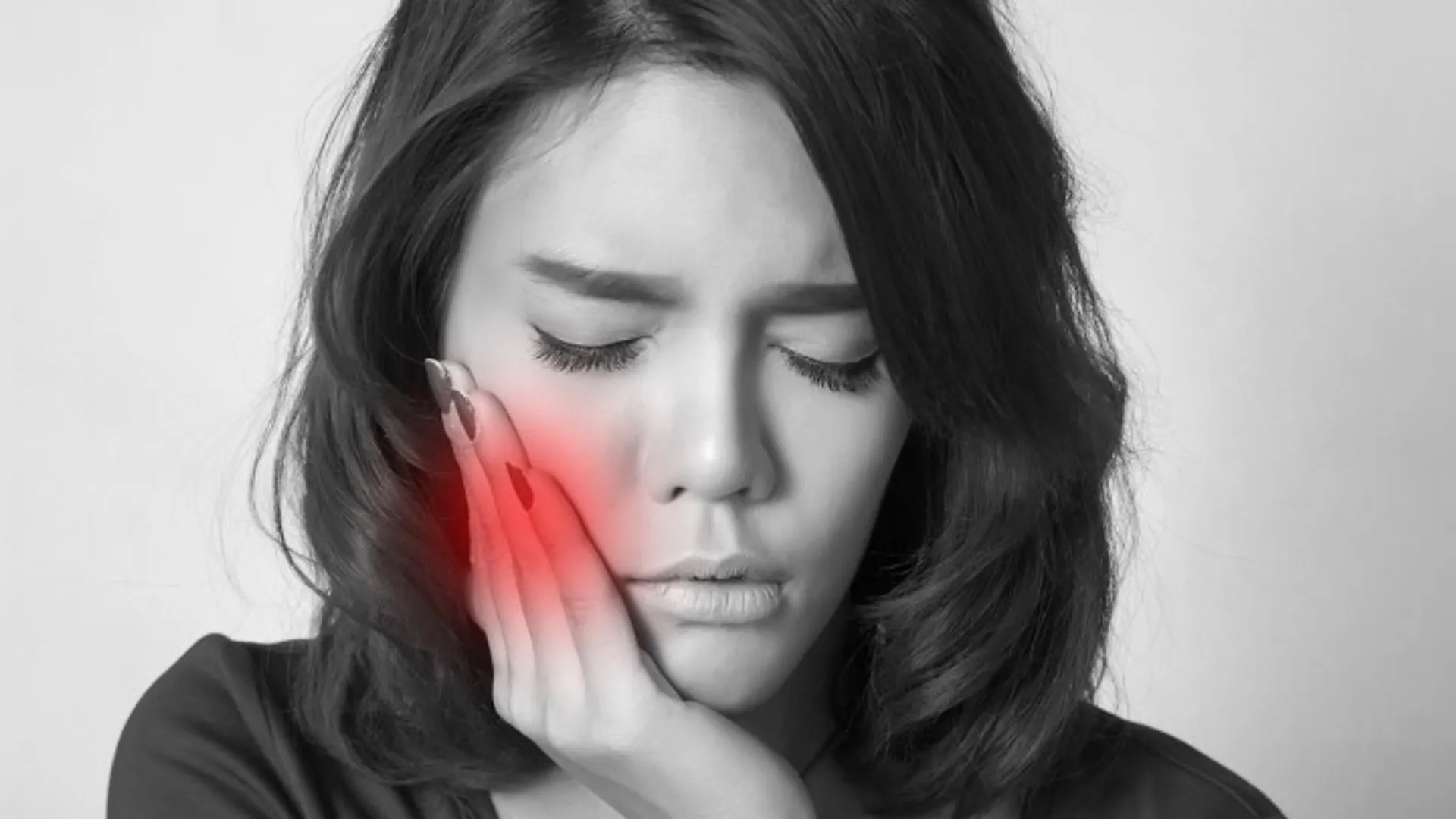 Woman holding jaw with tooth pain